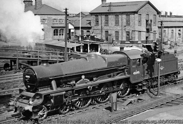 View NW from the footbridge at the north end of Crewe Station that used to lead into the North Locomotive Depot - and used to be thronged by young train-spotters. The Depot is seen behind as this resplendent LMS 'Jubilee' 6P 4-6-0 (No. 45595 'Southern Rhodesia') is probably being tested on its first day back in steam after repair at Crewe Works.