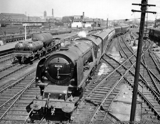 View northward from the footbridge, towards Manchester (to the right), Liverpool, Warrington and the North (centre) and Chester (left); ex-London & North Western West Coast Main Line and subsidiaries. Crewe North Junction signalbox is prominent in the centre and part of the Works is visible far left. The 10.15 Manchester London Road to Bournemouth West is headed by Stanier 'Coronation' 8P 4-6-2 No. 46236 'City of Bradford'. The mobile gas-cylinders are probably for replenishing the reservoirs on kitchen-cars.