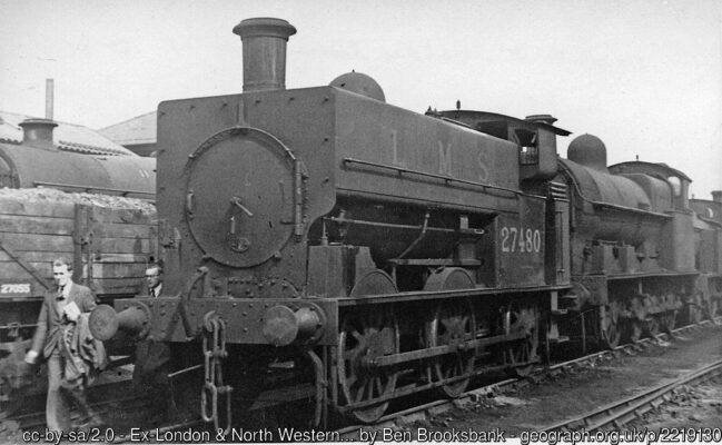 Although lined up with other condemned engines, No. 27480, which was converted from a tender engine, was still working as a Crewe Works shunter and not withdrawn until the end of 1948. (Passing beside it are two of my fellow-visitors to the Works on that memorable day).