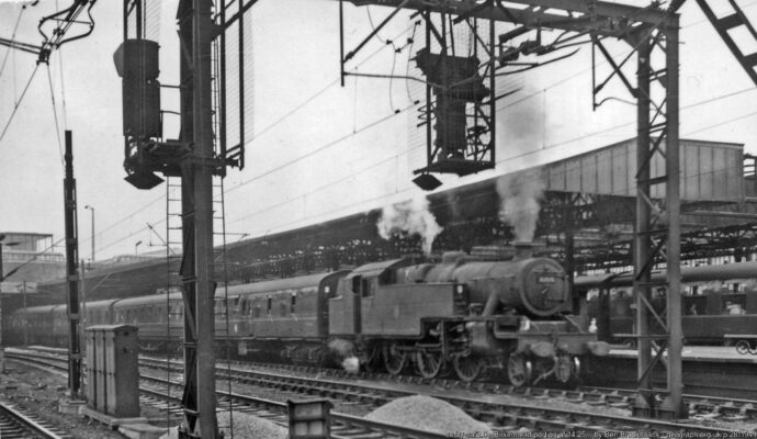 View SW, towards London and the South: WCML etc. The main part of the 14.25 Euston - Liverpool has gone ahead, leaving the Birkenhead portion to follow via Chester, behind Stanier 4MT 2-6-4T No. 42575 (built 1936, withdrawn 10/62 - only six months after this). With electric trains now working from Crewe to Manchester and to Liverpool, the gantries and wires are very prominent.