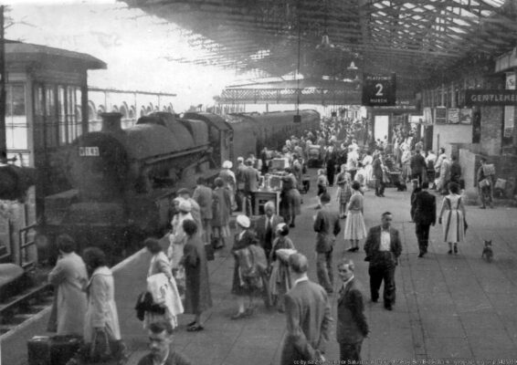 View southward on Platform 2, as the 13.05 Euston - Glasgow enters, headed by Stanier 'Jubilee' No. 45599 'Bechuanaland' (26/1/35 - 15/8/64). On the left is Crewe Station 'A' signal-box. (Note also how beautifully dressed the women were in those days).